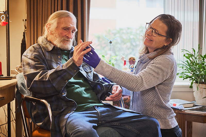 A Housecall Providers patient gets his vitals checked while sitting at his desk during a house call